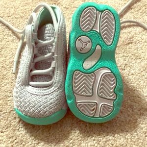 Grey tennis shoes with teal accent.